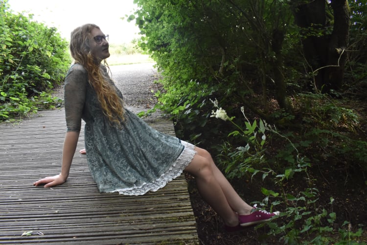 A short dress worn over a white lace underskirt to extend its length