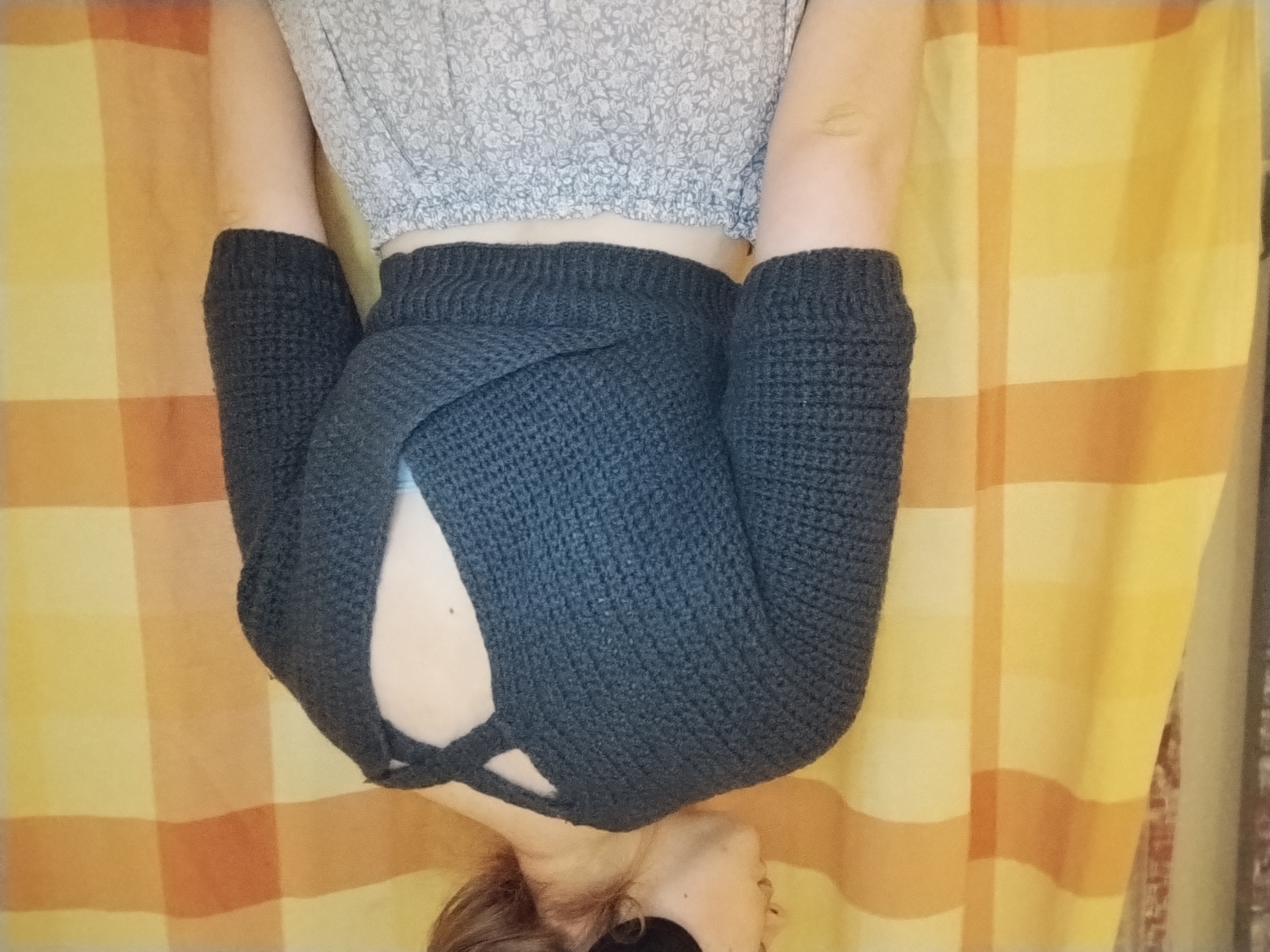Close-up of the chunky dark grey knitted wrap skirt, crossed and tied at the hip