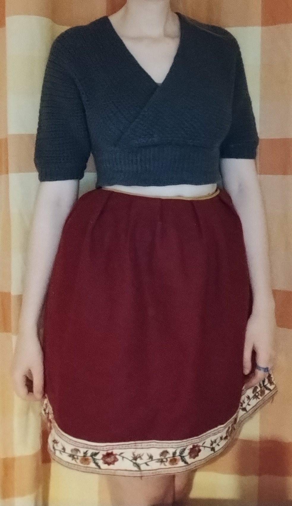 The red wool skirt worn with a navy knitted top, the drawstring waist gathered to fit