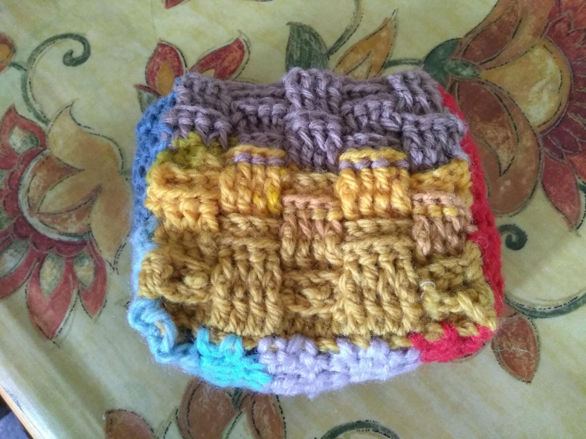 A small crocheted basketweave pouch in mustard and heather purple