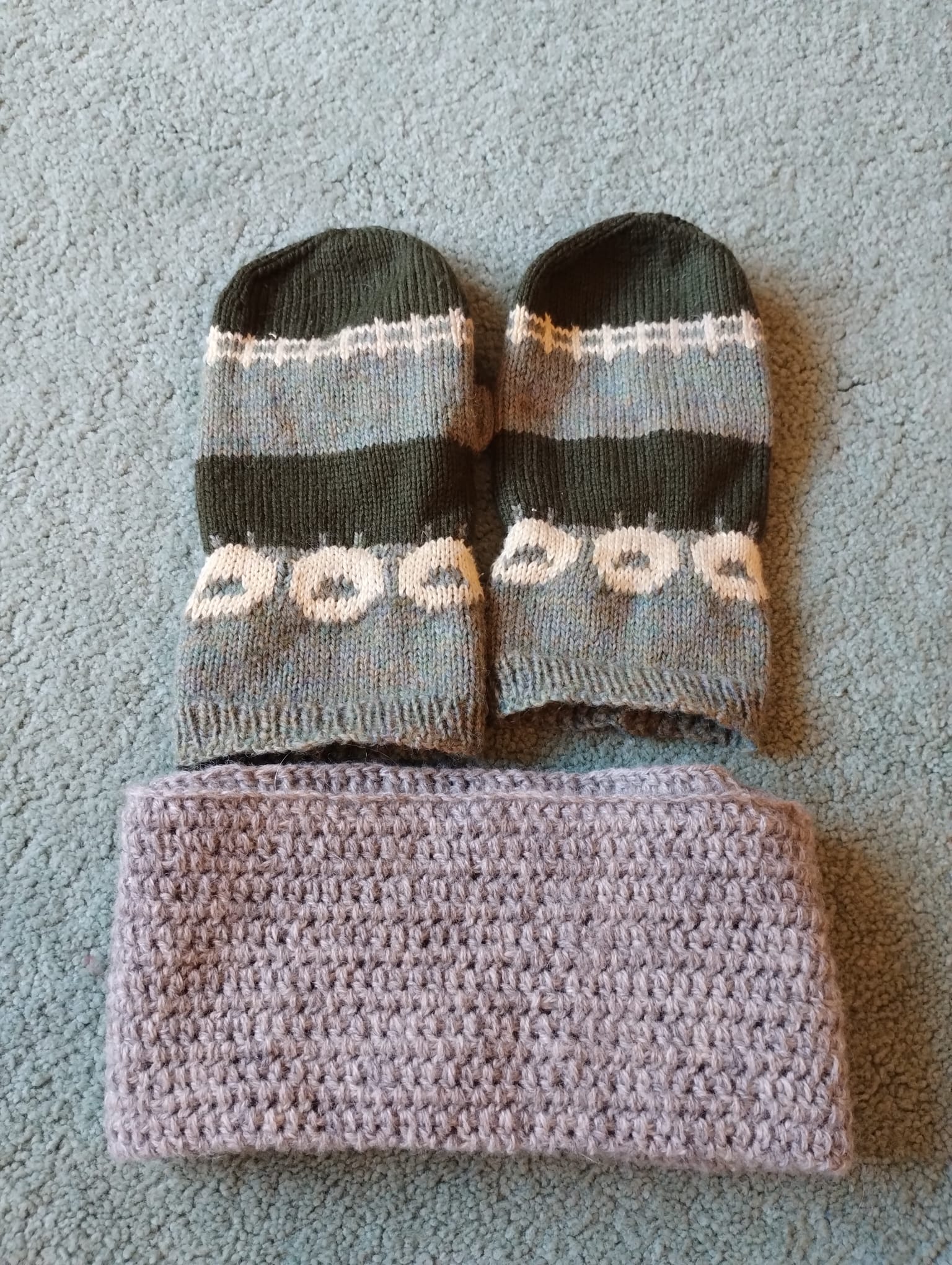 A pair of hand-knitted mittens with a different sheep pattern