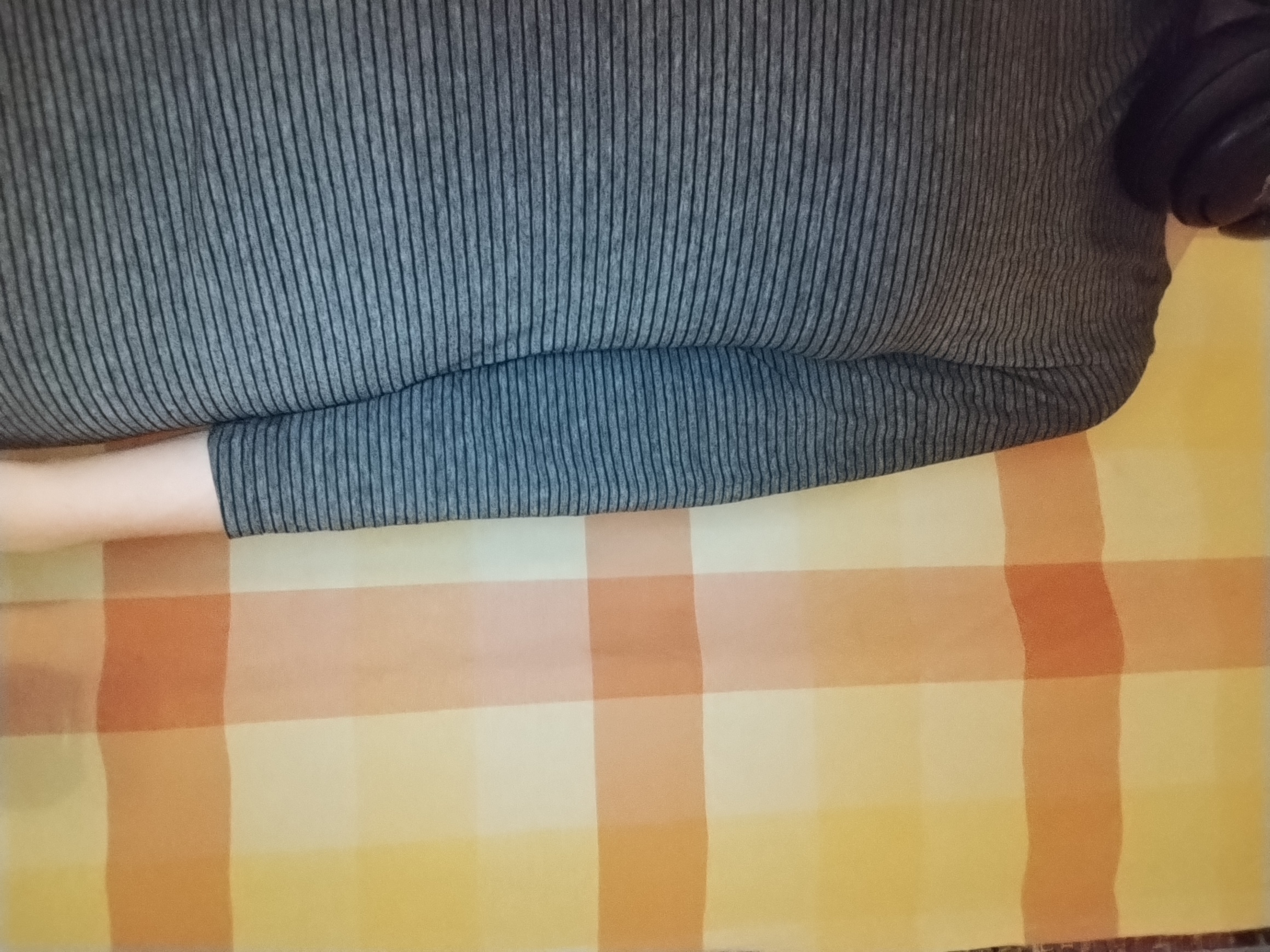 A grey ribbed three-quarter-sleeve top worn over a floral crop top